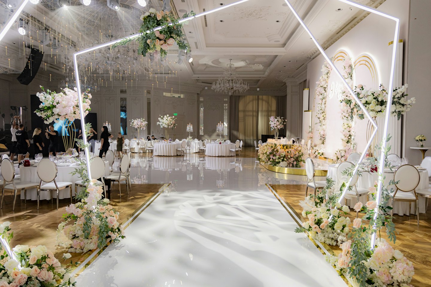 Elegancka sala bankietowa z kwiatami i nowoczesnym wystrojem.